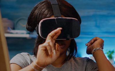 MINT-Praxisbeispiele: Technika Ortenau - nachhaltige MINT Entwicklung der Bildungsregion Ortenau. Dieses Foto zeigt eine junge Frau welche eine VR Brille trägt und mit der Hand auf etwas in der Luft zeigt.