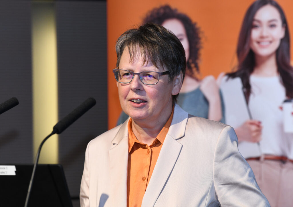 231005-MINT-Bilanzgespräch-BN Eine Frau kur kurzen grauen Haaren steht vor einem Mikrofon.