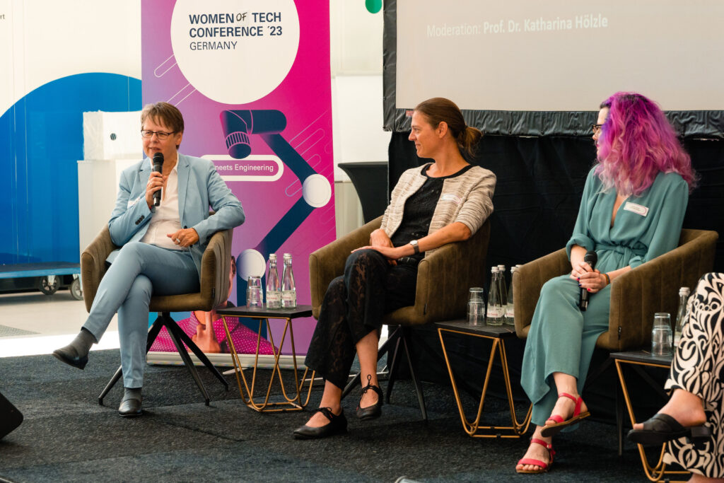 A7E00059 Drei Frauen sitzen auf einer Bühne auf Stühlen im Halbkreis und reden