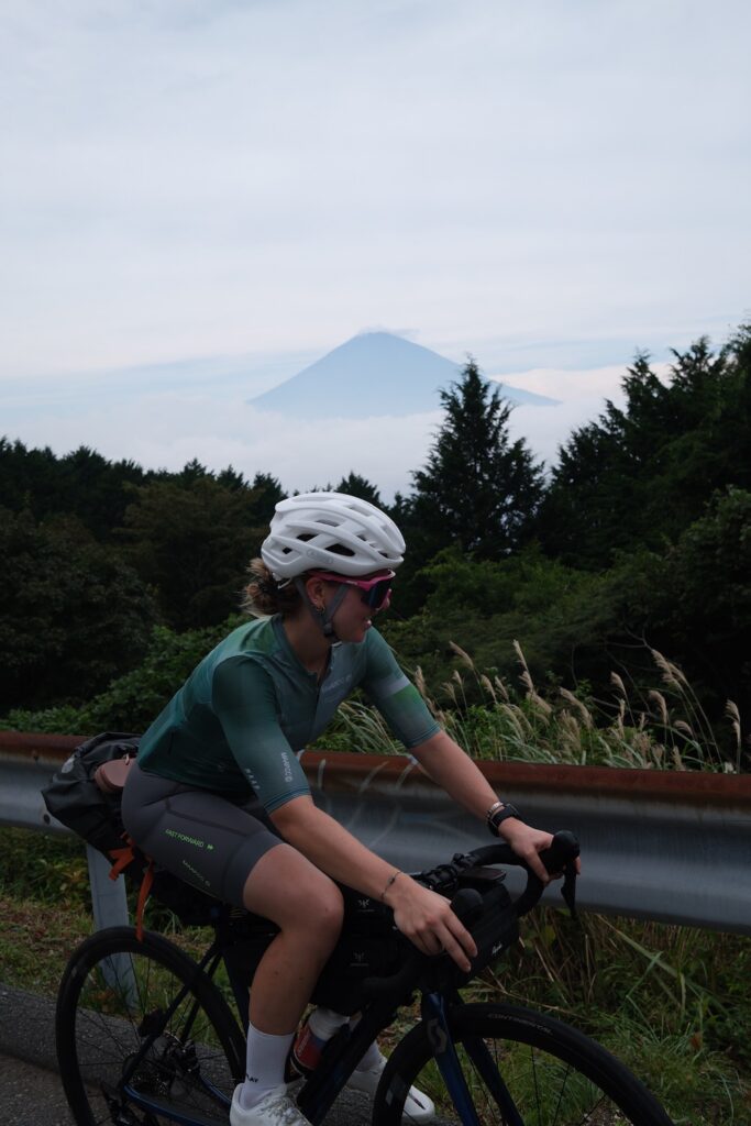 mint_portreat_soraya schwin Eine junge Frau auf einem Fahrrad vor einer bergigen Landschaft