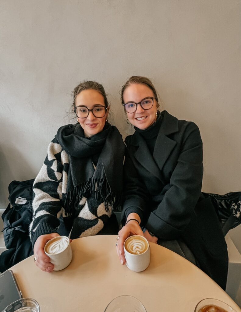 mint_portreat_soraya schwin Zwei junge Frauen sitzen in einem Kaffee aus einer Bank und haben Kaffeetassen in der Hand